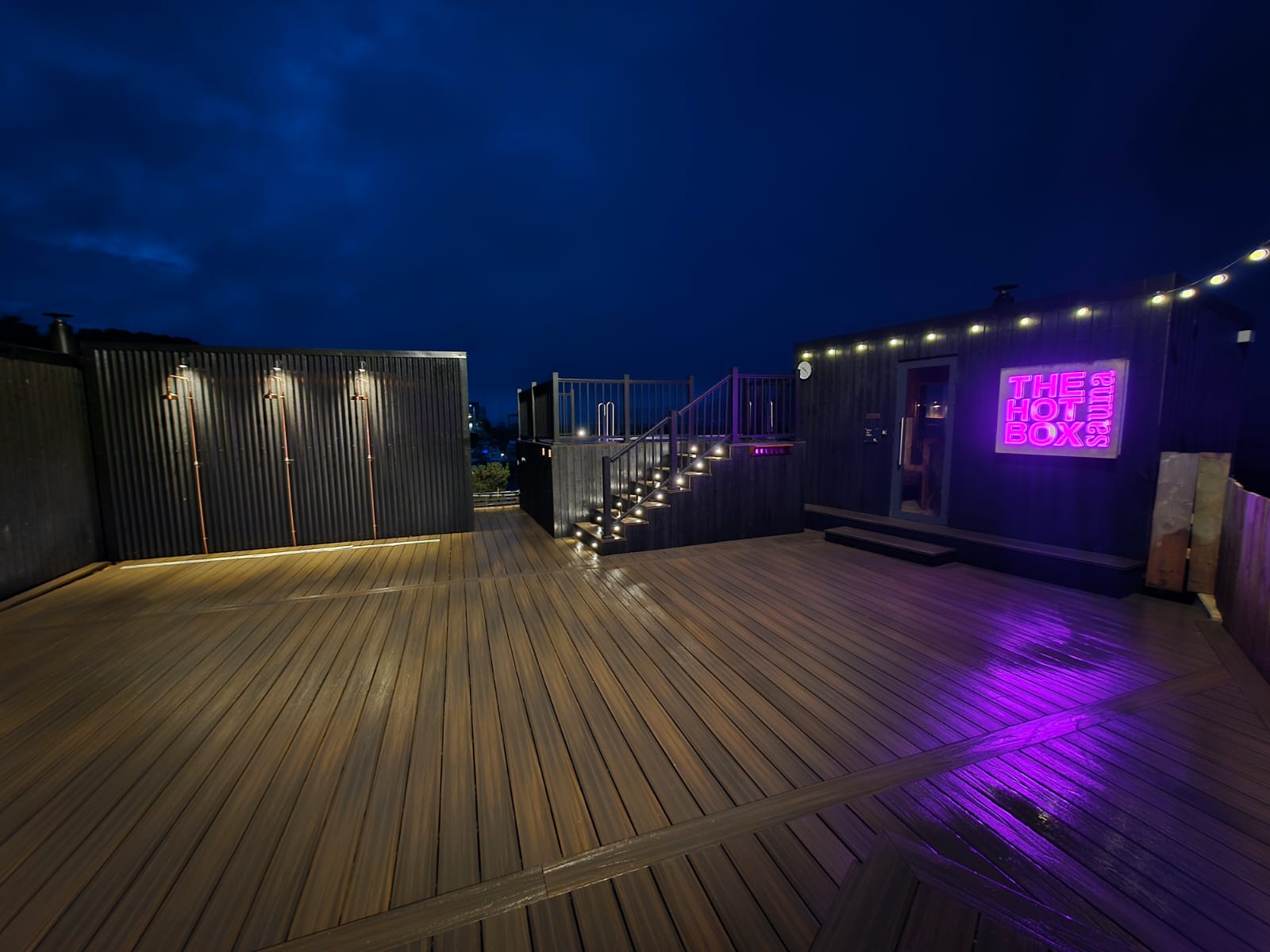 Wide composite deck with festoon lighting and balustrades at night