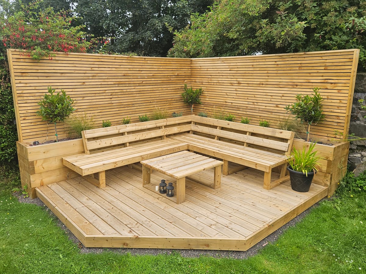 Hardwood corner deck with built-in bench seating and slatted screen in a Dundalk garden